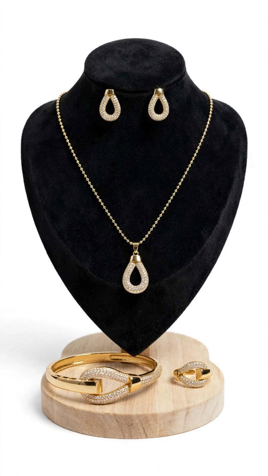 Gold pavé cubic zirconia 4-piece jewellery set including necklace, earrings, bangle and ring on black velvet display