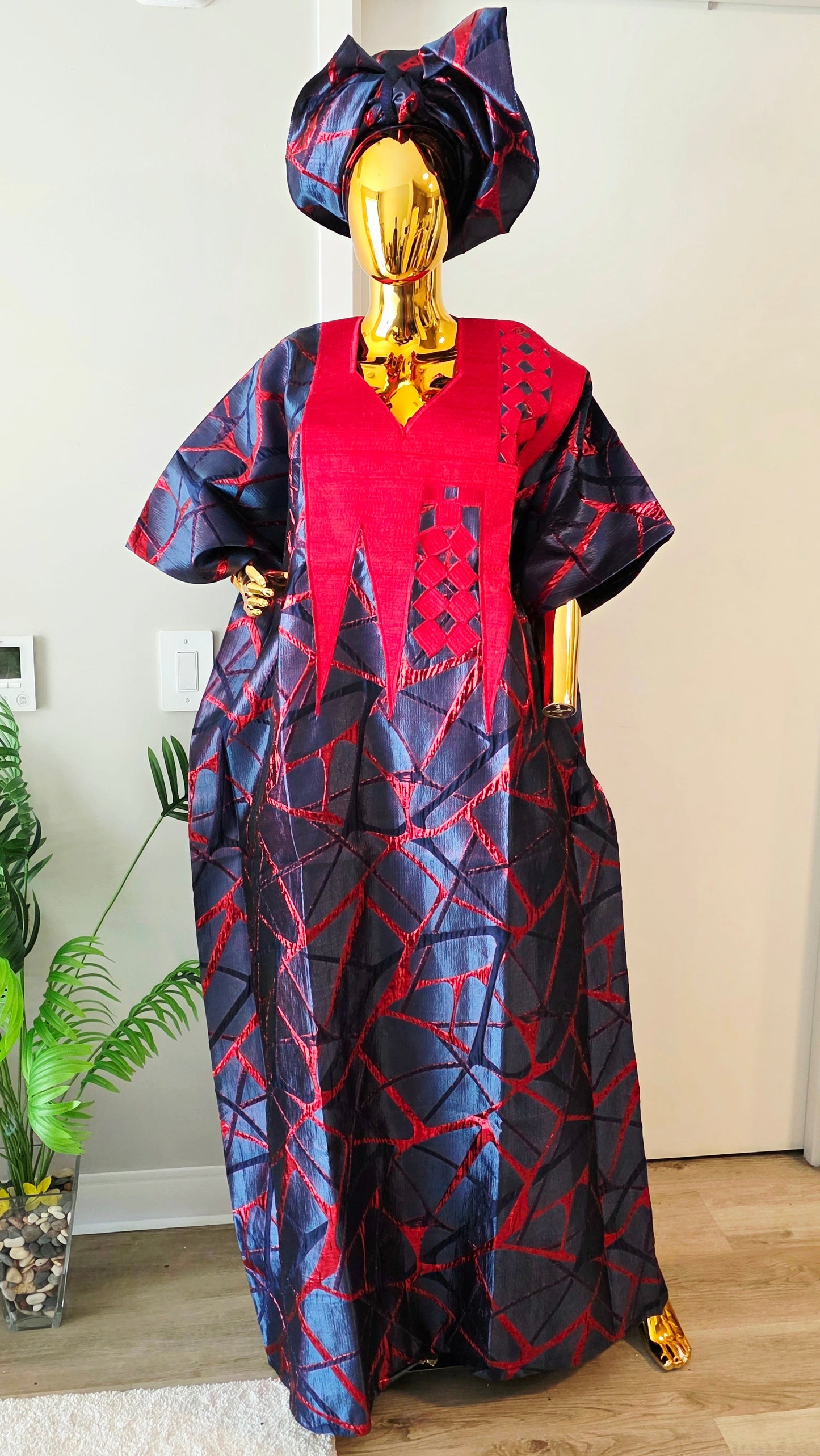 Navy and red aso oke boubou set with geometric embroidery and matching gele headwrap on gold mannequin